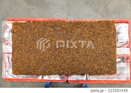 The close up image of the jagged brown natural raw rubber bales surface, lumpy solid block standard Thai rubber, in a factory. 123501430