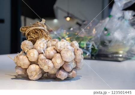 Garlic Bundle in studio light on the white marble surface table, prepare for a food demonstration behind. 123501445