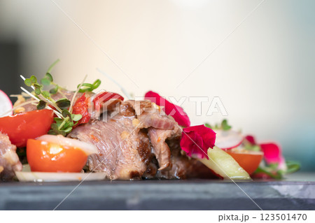 Close up to Spicy Thai Beef Salad garnished on top with cress and micro herb was put on a rectangular stone plate. Close up to Spicy Thai Beef Salad garnished on top with cress and micro herb was put on a rectangular stone plate. 123501470