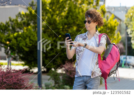 Happy tourist man using smartphone typing text messages browsing internet social media web app Happy tourist man using smartphone typing text messages browsing internet social media web app 123501582