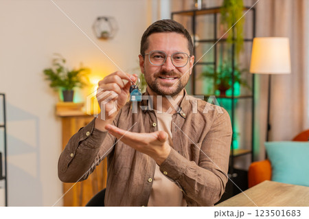 Happy businessman real estate agent using laptop at home office desk showing the keys of new house Happy businessman real estate agent using laptop at home office desk showing the keys of new house 123501683