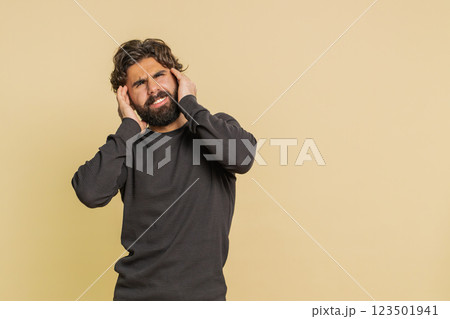 Lebanese bearded man in long sleeves rubbing temples to cure headache problem on beige background 123501941