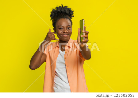 African American woman holding smartphone call me hand gesture confident expression contact reminder 123502055