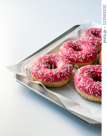 Pink donuts on metal tray and white table 123503332