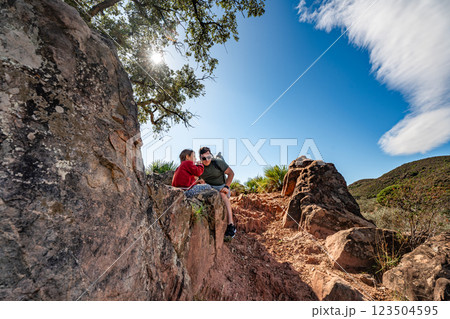 Father and child hiking in sunny rocky landscape with blue sky 123504595