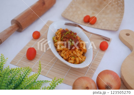 Macaroni with tomato sauce and onions on a white plate. Macaroni with tomato sauce and onions on a white plate. 123505270