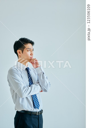 考え事をするワイシャツ姿の若い男性 考え事をするワイシャツ姿の若い男性 123506109