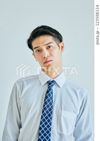 首をかしげるワイシャツ姿の若い男性 首をかしげるワイシャツ姿の若い男性 123506114