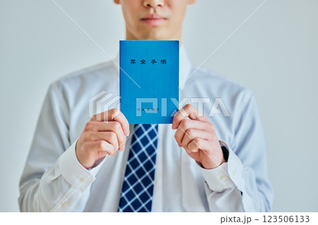 年金手帳を持つ20代の若い男性 年金手帳を持つ20代の若い男性 123506133