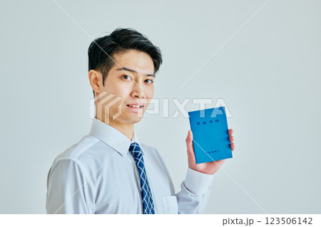 年金手帳を持つ20代の若い男性 123506142