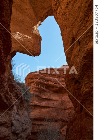 Natural sandstone arch. View through arch to blue sky. Passage inside the canyon 123507754