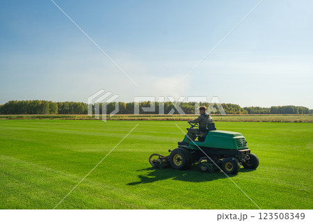 The Importance of Green Lawn Landscape Maintenance Utilizing a Riding Mower for Growth Efficiency and Density 123508349