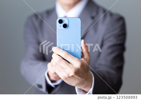 グレーのスーツを着てスマホで撮影をするミドル男性ビジネスマン 123508993