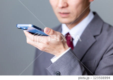 グレーのスーツを着てスマホで通話するミドル男性ビジネスマン 123508994