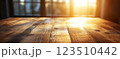 Wooden Table Surface with Sunset Blurry Cityscape and Nature Background, Warm Tones, and Soft Focus Lights Creating a Cozy Atmosphere for Relaxation 123510442