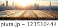 Wooden Table Surface with Sunset Blurry Cityscape and Nature Background, Warm Tones, and Soft Focus Lights Creating a Cozy Atmosphere for Relaxation 123510444