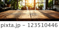 Wooden Table Surface with Sunset Blurry Cityscape and Nature Background, Warm Tones, and Soft Focus Lights Creating a Cozy Atmosphere for Relaxation 123510446