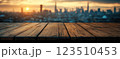 Wooden Table Surface with Sunset Blurry Cityscape and Nature Background, Warm Tones, and Soft Focus Lights Creating a Cozy Atmosphere for Relaxation 123510453