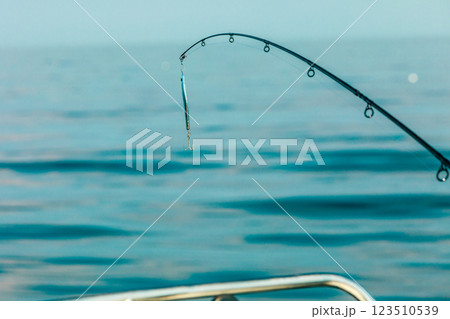saltwater fishing - rod with wobbler and blue sea water saltwater fishing - rod with wobbler and blue sea water 123510539