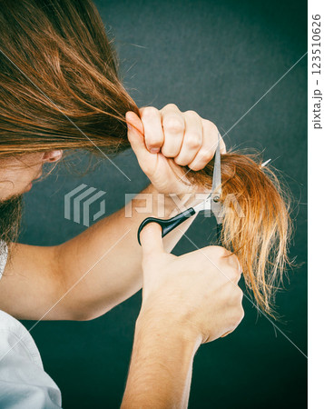 Male hands cutting long hair 123510626