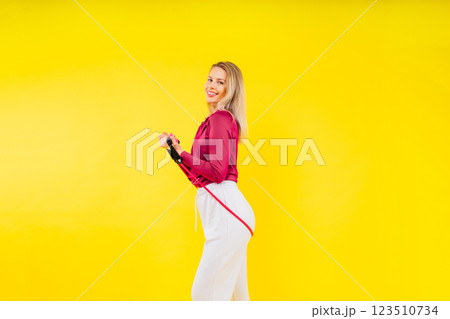 Fitness and sport concept. Portrait of smiling young woman wearing sportswear posing isolated Fitness and sport concept. Portrait of smiling young woman wearing sportswear posing isolated 123510734