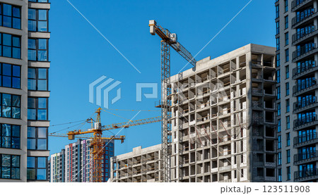 Construction of modern high-rise building in urban area. Crane at work on unfinished condo, part of 123511908