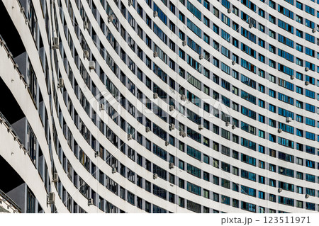 Modern multistory residential building with a sleek concrete facade in a vibrant urban neighborhood. 123511971