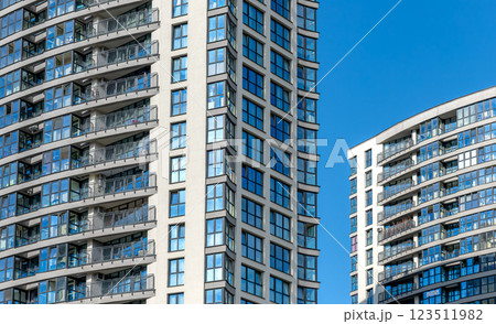 Tall modern building in urban neighborhood. New multi-story condominium under development, with 123511982