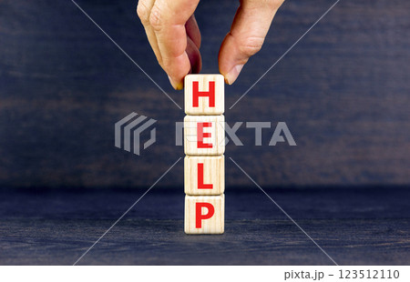 Help symbol. Concept word Help on beautiful wooden blocks. Businessman hand. Beautiful black table black background. Business, lifestyle, support and help concept. Copy space. 123512110