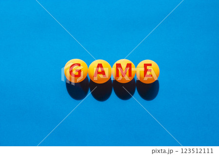 Game symbol. Concept word Game on beautiful yellow ping pong balls. Beautiful blue table blue background. Business, lifestyle and game concept. Copy space. 123512111