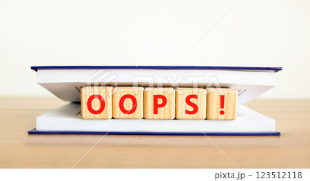 Oops symbol. Concept word Oops on beautiful wooden blocks in book. Beautiful wooden table white background. Business lifestyle oops concept. Copy space. Oops symbol. Concept word Oops on beautiful wooden blocks in book. Beautiful wooden table white background. Business lifestyle oops concept. Copy space. 123512118