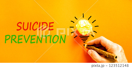 Suicide prevention symbol. Concept words Suicide prevention on beautiful orange paper. Psychologist hand. Beautiful orange table orange background. Psychological suicide prevention concept. Copy space 123512148