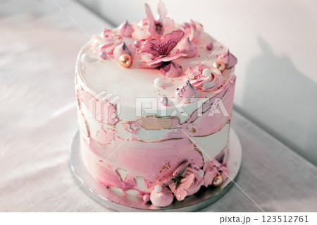 Birthday cake decorated with pink sugar flowers and butterflies. 123512761