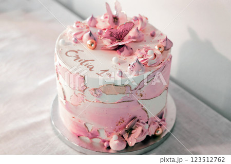 Birthday cake decorated with pink sugar flowers and butterflies. 123512762