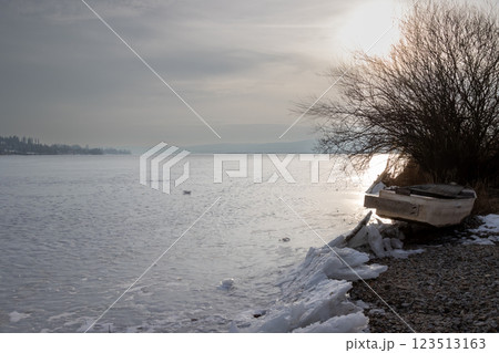 Frozen Lipno and a boat on the coast, Czechia Frozen Lipno and a boat on the coast, Czechia 123513163