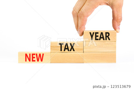 New tax year symbol. Concept words New tax year on beautiful wooden blocks. Beautiful white table white background. Businessman hand. Business new tax year concept. Copy space. 123513679