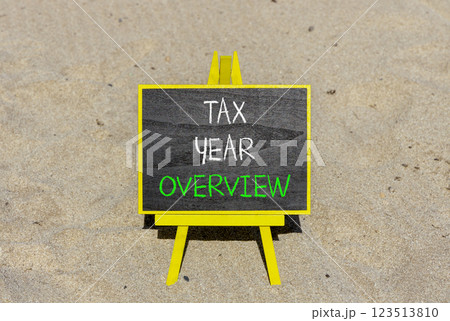 Tax year overview symbol. Concept words Tax year overview on beautiful black yellow blackboard. Beautiful sand beach background. Business tax year overview concept. Copy space. 123513810