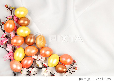 Easter eggs on a light elegant background with sakura branches, ideas for homemade Easter preparations. Marble eggs painted with golden turmeric, Easter celebration concept 123514069
