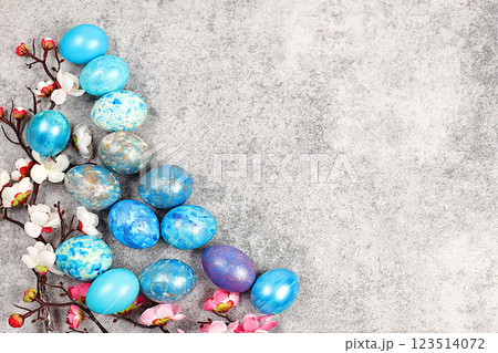 Blue marble easter eggs painted with blue moonlight on grey concrete background with sakura branches, easter homemade cooking ideas, easter celebration concept Blue marble easter eggs painted with blue moonlight on grey concrete background with sakura branches, easter homemade cooking ideas, easter celebration concept 123514072