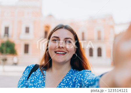 Happy 30s Woman takes selfie on urban background. Traveler visiting Valencia Cathedral. Summer Holidays in Spain. Female is exploring city. Top tourist attraction 123514121