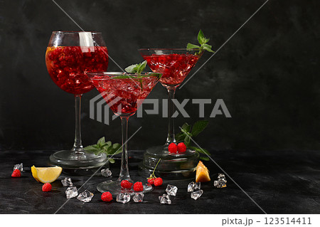 Lemonade cocktail with tequila, gin, rum, vodka, liqueur, lime, ice and fresh raspberries, bar and party concept, restaurant and cafe advertising card, black background, selective focus Lemonade cocktail with tequila, gin, rum, vodka, liqueur, lime, ice and fresh raspberries, bar and party concept, restaurant and cafe advertising card, black background, selective focus 123514411