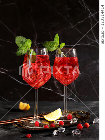 Royal alcoholic lemonade cocktail with lime, ice and fresh raspberries, bar and party concept, restaurant and cafe advertising card, black background, selective focus Royal alcoholic lemonade cocktail with lime, ice and fresh raspberries, bar and party concept, restaurant and cafe advertising card, black background, selective focus 123514414