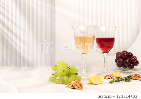 Tasting noble varieties of red and white wine in glasses with grape varieties, nuts and rosemary, concept of wine tasting and summer party. Advertising banner for cafe and restaurant, modern still Tasting noble varieties of red and white wine in glasses with grape varieties, nuts and rosemary, concept of wine tasting and summer party. Advertising banner for cafe and restaurant, modern still 123514432