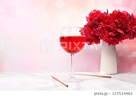 Festive alcoholic cocktail, red wine in glasses on a bright background with a bouquet of burgundy peonies, summer bar concept, alcoholic drinks at a party, restaurant and cafe advertising, selective 123514462