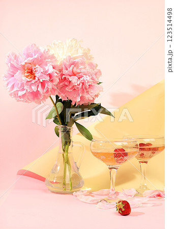 Modern still life with pink martini, alcoholic cocktail with champagne, strawberries and peony flowers on elegant modern background, minimal concept for bar and holiday party, cafe, advertising Modern still life with pink martini, alcoholic cocktail with champagne, strawberries and peony flowers on elegant modern background, minimal concept for bar and holiday party, cafe, advertising 123514498