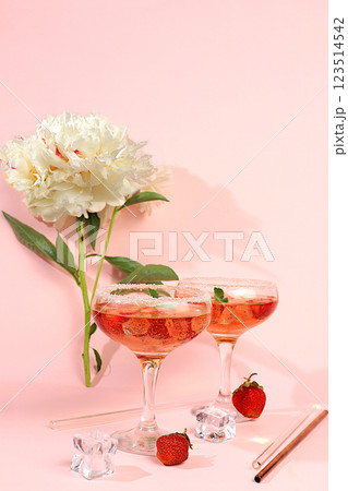 Modern still life with pink martini, alcoholic cocktail, strawberries and peony flowers on elegant modern background, minimal concept for bar and holiday party, cafe, advertising banner, selective Modern still life with pink martini, alcoholic cocktail, strawberries and peony flowers on elegant modern background, minimal concept for bar and holiday party, cafe, advertising banner, selective 123514542