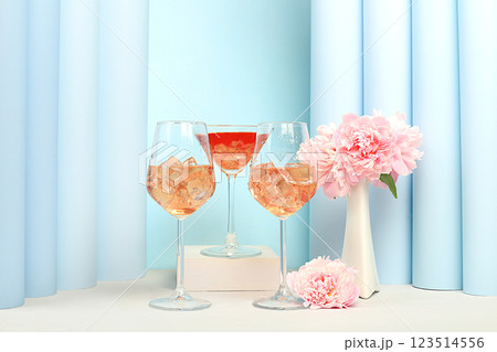 Modern summer still life with alcoholic cocktail Aperol spritz, champagne, pink martini and peony flowers on elegant modern background, minimal concept for bar and holiday party, cafe, advertising Modern summer still life with alcoholic cocktail Aperol spritz, champagne, pink martini and peony flowers on elegant modern background, minimal concept for bar and holiday party, cafe, advertising 123514556
