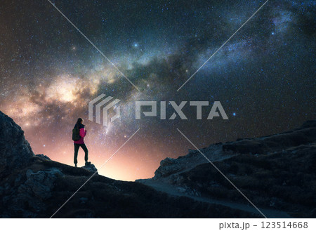 Glowing Milky Way and woman on mountain peak at starry night 123514668