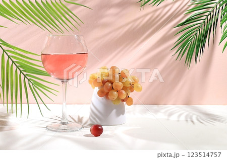 Modern still life with white wine, alcoholic cocktail and grapes on pastel background with long hard shadows, minimal concept for bar, cafe, advertising banner, selective focus, space for text 123514757