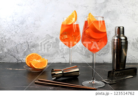 Festive alcoholic cocktail Aperol spritz in glasses on a dark background, concept for bar and New Year's Eve, alcoholic drinks at a party, advertising for a restaurant, selective focus Festive alcoholic cocktail Aperol spritz in glasses on a dark background, concept for bar and New Year's Eve, alcoholic drinks at a party, advertising for a restaurant, selective focus 123514762